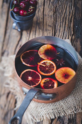 Roter Glühwein in einem Topf mit Orangen 